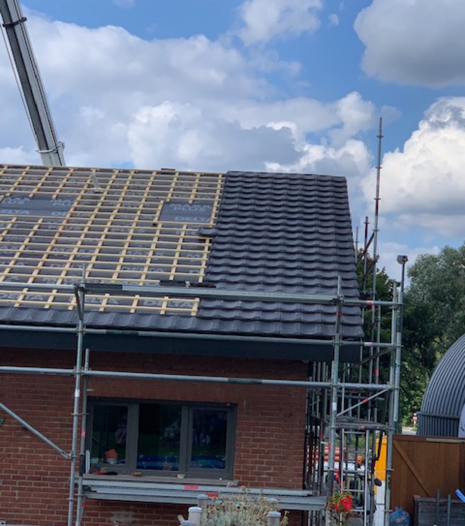 Eerste dakpannen geplaatst op een hellend dak